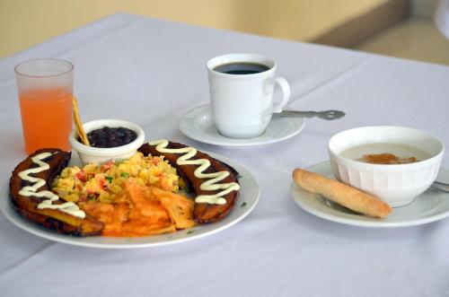 a table with a plate of food and a cup of coffee at Hotel y Restaurante Castillo de los Altos in Quetzaltenango