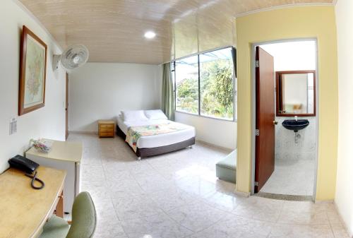 a bedroom with a bed and a desk and a window at Centro Recreacional IASCEBOY in Barbosa