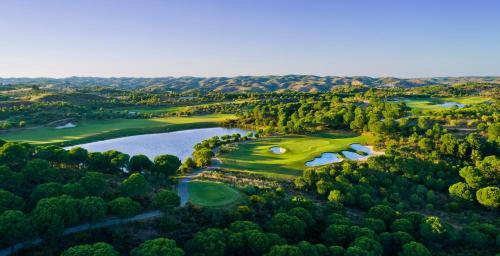 a large body of water with palm trees at Monte Rei Golf & Country Club in Vila Nova De Cacela