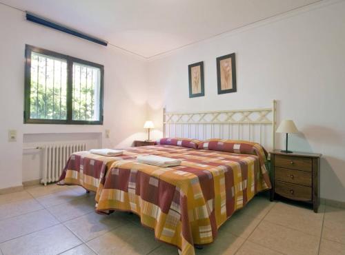 a bedroom with a bed with a striped blanket and a table at Villa Stefan - Plusholidays in Calpe