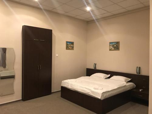 a bedroom with a bed and a cabinet in it at Casa IDA 1896 in Galaţi