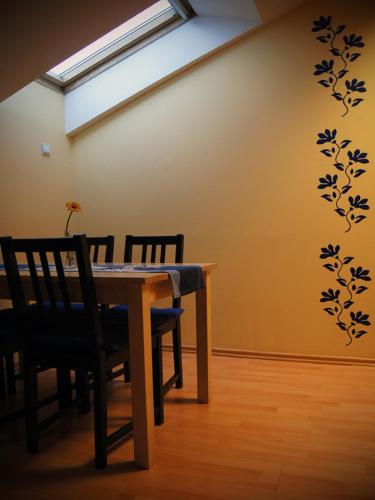 a dining room with a table and chairs and a wall at Green Hostel Wrocław przy ZOO in Wrocław
