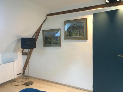 a room with a blue door and two pictures on the wall at Numéro 7 in Le Tronquay