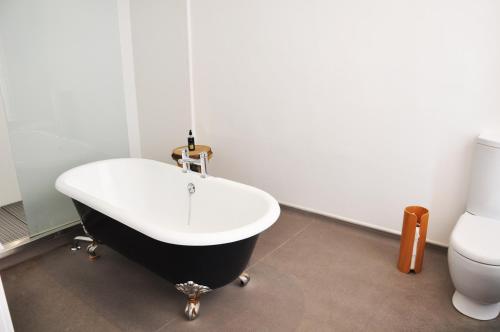 a bathroom with a black and white bath tub next to a toilet at Carmelite Hotel in Aberdeen