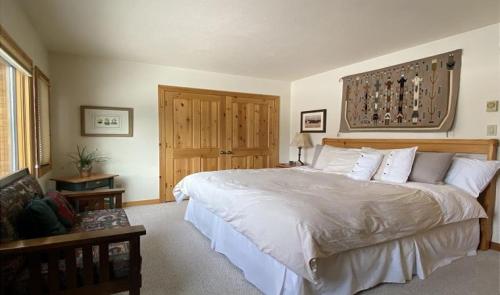 a bedroom with a large white bed with white pillows at Glacier in Jackson