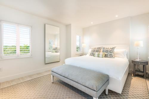 a white bedroom with a large bed and a window at The Islands of Islamorada in Islamorada