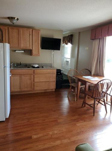 a kitchen with a table and chairs and a white refrigerator at Windrifter Resort in Wolfeboro