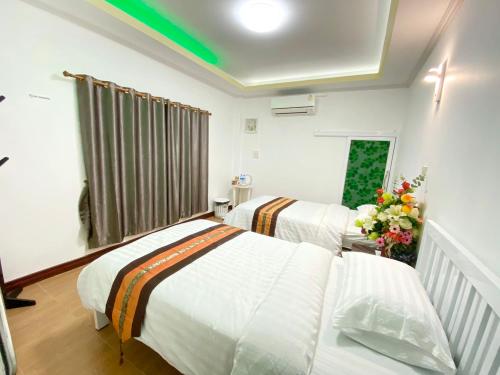 a hotel room with two beds and flowers in it at ดอยตุง ฮันนาห์ โฮมสเตย์ in Ban Pa Kluai La Hu