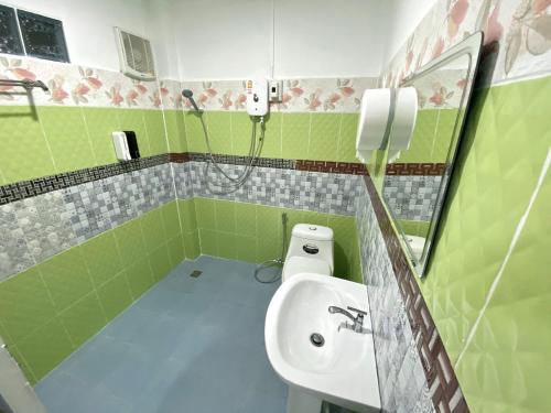 a green bathroom with a sink and a toilet at ดอยตุง ฮันนาห์ โฮมสเตย์ in Ban Pa Kluai La Hu