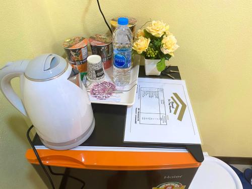a table with a tea kettle and flowers on it at ดอยตุง ฮันนาห์ โฮมสเตย์ in Ban Pa Kluai La Hu