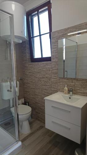 uma casa de banho com um lavatório, um WC e um espelho. em Central Vendégház em Baja