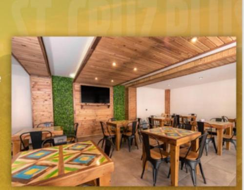 a restaurant with wooden tables and chairs and a flat screen tv at ST CRUZ PLUS in Creel
