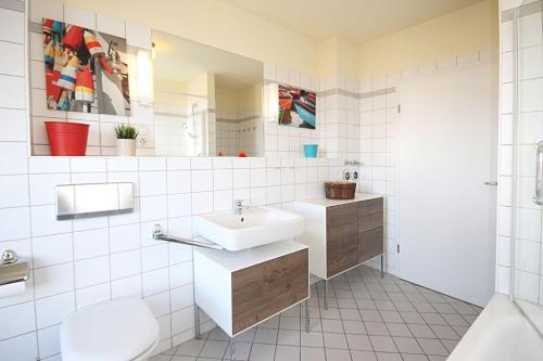 キュールングスボルンにあるHaus-Amber-Mare-Blumenmeer-9318の白いバスルーム(洗面台、トイレ付)