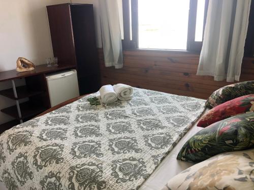 a bedroom with a bed with a towel on it at Pousada Tranquila in Morro de São Paulo