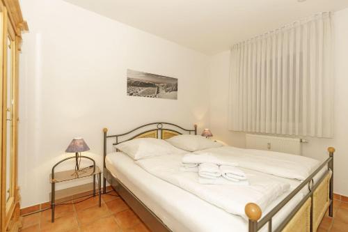 キュールングスボルンにあるHaus-Meeresblick-Wohnung-E-03-400のベッドルーム1室(ベッド1台、タオル2枚付)