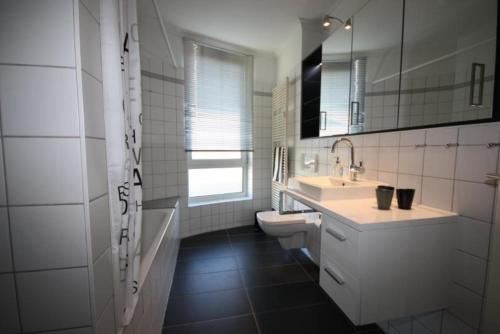 a white bathroom with a sink and a toilet at Haus-Amber-Mare-Strandtraeumer-9695 in Kühlungsborn