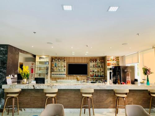 a bar in a restaurant with stools at TRYP by Wyndham Manaus Aeroporto in Manaus