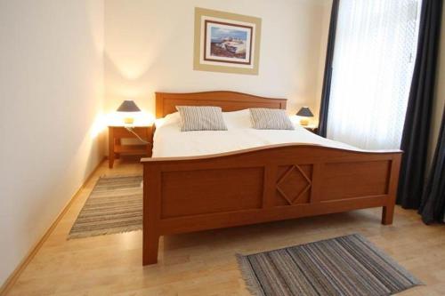 キュールングスボルンにあるStrandstrasse-Wohnung-28-9408のベッドルーム1室(大型木製ベッド1台付)