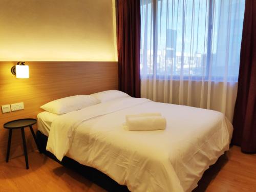 EZ Suites في بندر سيري بيغاوان: سرير في غرفة الفندق مع نافذة كبيرة