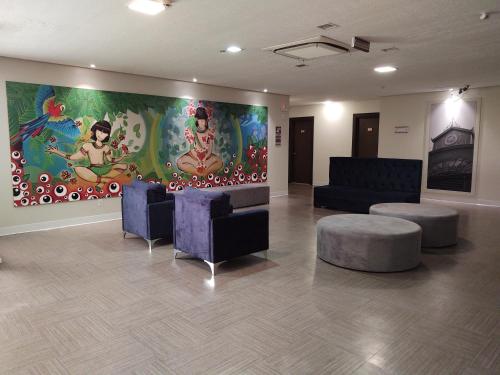 a lobby with couches and a large painting on the wall at TRYP by Wyndham Manaus Aeroporto in Manaus