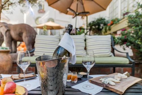 a bottle of wine in a bucket on a table with glasses at L'Auberge Carmel, Relais & Chateaux in Carmel
