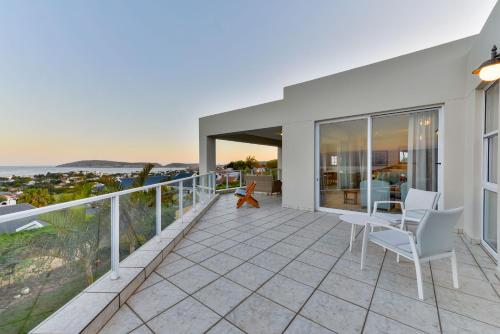a house with a balcony with a view of the ocean at Plettenberg View in Plettenberg Bay