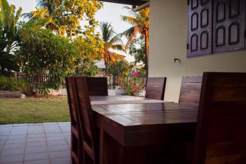 Une table et des chaises en bois sont disponibles sur la terrasse. dans l'établissement LA KAZ KRÉOL, à Cayenne