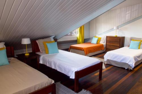 Cette chambre mansardée comprend deux lits et une chaise. dans l'établissement LA KAZ KRÉOL, à Cayenne