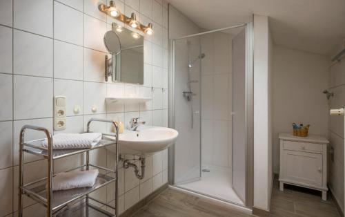 een witte badkamer met een wastafel en een douche bij Bergbauernhof Hinterseebach in Oberaudorf