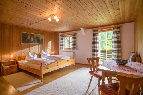 Un dormitorio con una cama y una mesa en una habitación. en Bergbauernhof Hinterseebach, en Oberaudorf
