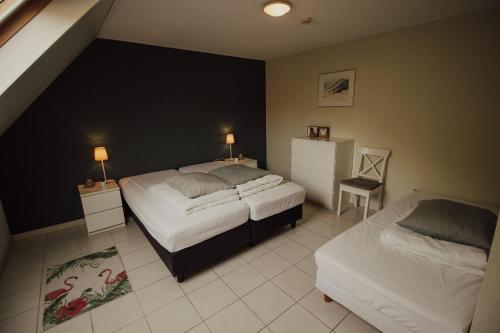 1 dormitorio con 2 camas y 2 mesas con lámparas en 't Veulenkot, en Retranchement