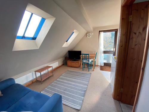 a living room with a blue couch and a table at The Rose Cottage Inn in Selmeston