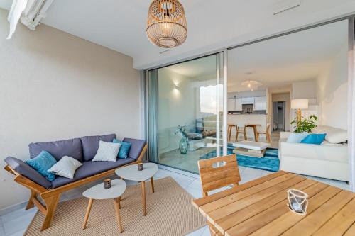 una sala de estar con un sofá y una mesa en Le Grand Large par Dodo à Cassis, en Cassis