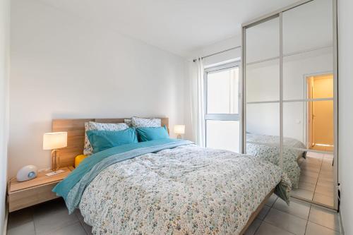 Un dormitorio con una cama y un espejo grande. en Le Grand Large par Dodo à Cassis, en Cassis