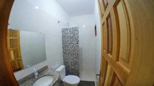 ein Bad mit einem Waschbecken, einem WC und einer Dusche in der Unterkunft Pousada Mar&Isa 1 in Itaúnas