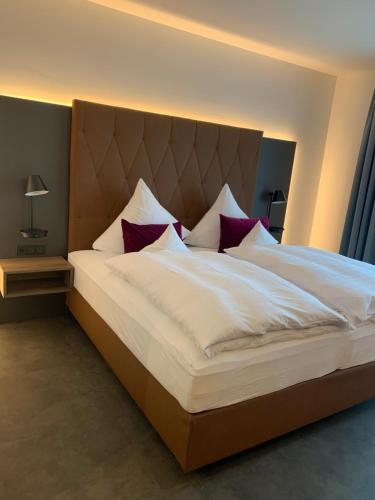 Emils Hotel في بيرماسونس: غرفة نوم مع سرير أبيض كبير مع وسائد حمراء
