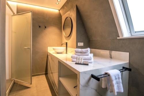 ein Bad mit einem Waschbecken und einem Spiegel in der Unterkunft Apart! & Moment! in De Haan