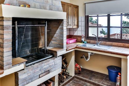 een keuken met een bakstenen oven bij CASA VILA in Garafía