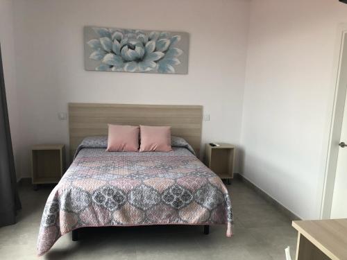 1 dormitorio con 1 cama con 2 almohadas rosas en hostal la taurina, en Santa Olalla de Toledo