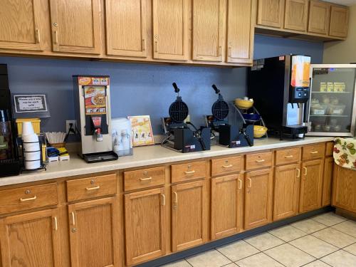 een keuken met houten kasten en een aanrechtblad bij Days Inn by Wyndham Hinckley in Hinckley