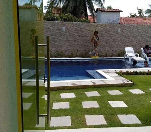 uma mulher ao lado de uma piscina em FLAT PRAIA DOS CARNEIROS / TAMANDARÉ 06 TÉRREO no Recife