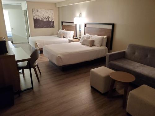 a hotel room with two beds and a couch at Wyndham Garden San Diego in San Diego