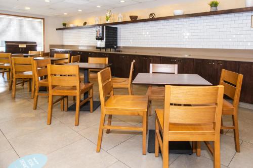 a dining room with wooden tables and chairs at Country Inn & Suites by Radisson, Rapid City, SD in Rapid City