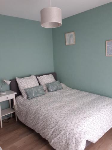 a bedroom with a bed with blue walls and a lamp at Edouard Grimaux in Poitiers