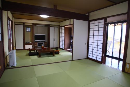 a room with a living room with a tv at Yufuin-Sanso Waremokou in Yufuin
