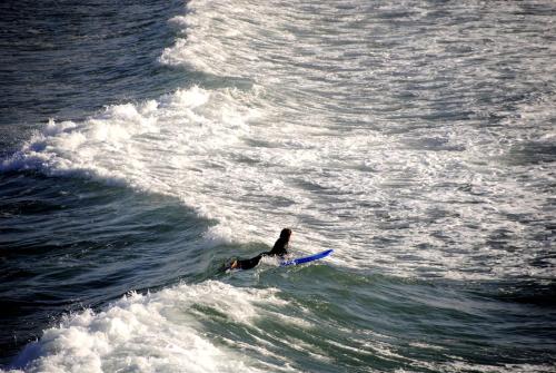 a person riding a wave on a surfboard in the ocean at Tigmi Blue - Imsouane Surf et Océan in Imsouane
