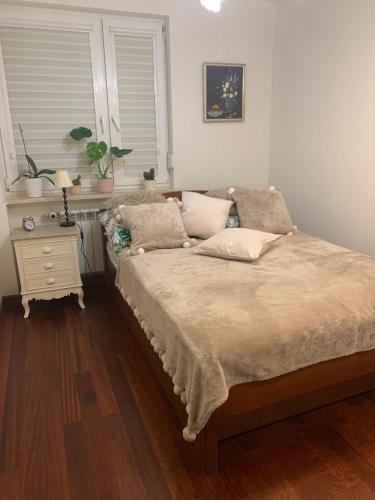 a bedroom with a bed with a nightstand and a window at Apartament Stylowy Pruszków Centrum in Pruszków