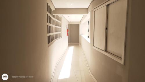 a hallway with a white tile floor and a white wall at Apartamento 2 quartos May Way Meireles uma quadra da Beira-mar in Fortaleza