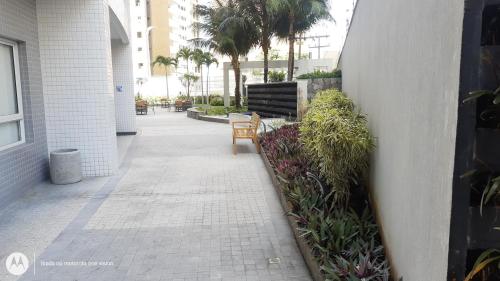 a walkway with benches and plants in a building at Apartamento 2 quartos May Way Meireles uma quadra da Beira-mar in Fortaleza