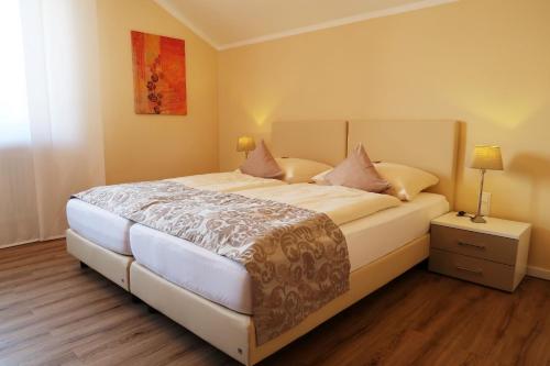a bedroom with a large white bed with pillows at Hotel garni Bellevue in Bad Füssing